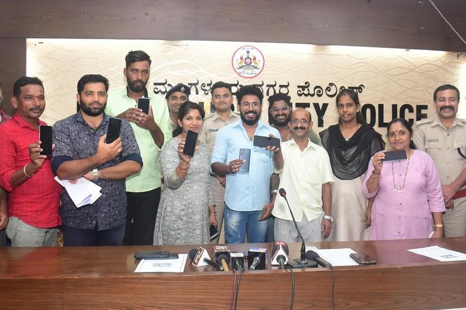 Mangaluru City Police with citizens holding up the mobile phones returned to them